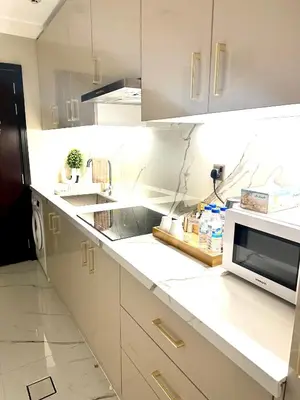 a kitchen with white cabinets and a microwave at Stunning Studio with Sea-View in Jumeirah Lake Towers JLT in Dubai
