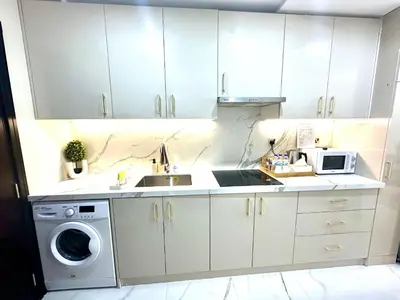 a white kitchen with a sink and a washing machine at Stunning Studio with Sea-View in Jumeirah Lake Towers JLT in Dubai