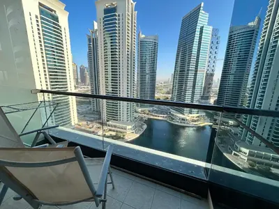 a chair on a balcony with a view of a city at Click Stay - JLT - 2 Bedroom & Balcony Lakes view Entire Apartment -AZ in Dubai