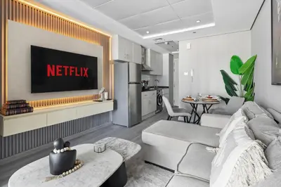 a living room with a couch and a tv at Chic JLT Studio Lake View Metro 5min Marina in Dubai