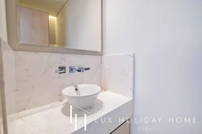 a bathroom with a white sink and a mirror at LUX Iconic Views at The Palm Tower Suite 5 in Dubai
