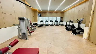 a gym with a row of treadmills and ellipticals at LUX Iconic Views at The Palm Tower Suite 5 in Dubai