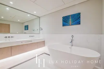 a bathroom with a tub and a large mirror at LUX Iconic Views at The Palm Tower Suite 5 in Dubai