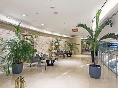 a lobby with potted plants and tables and chairs at Burj Khalifa & Fountain From Your Balcony Near Dubai Mall & Metro in Dubai