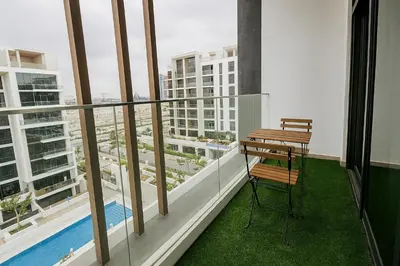 a balcony with a table and chair on a building at Spacious Comfortable Apartment for your Family or you Group in Dubai