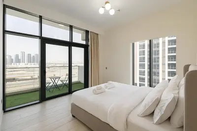 a bedroom with a large white bed and large windows at Spacious Comfortable Apartment for your Family or you Group in Dubai