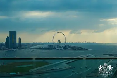 a ferris wheel in the middle of a city at Westminster Beach Front in Dubai