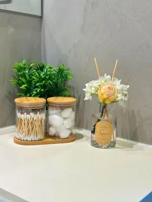 two mason jars with flowers and plants on a table at Luxury Burj Khalifa & Canal View Apartment, Business Bay, Downtown Dubai in Dubai
