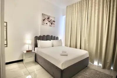 a bedroom with a bed and a large window at 2BR Duplex Stunning Views,Near Circle Mall & Park in Dubai