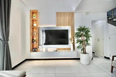 a living room with a tv on a white wall at 2BR Duplex Stunning Views,Near Circle Mall & Park in Dubai