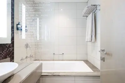 a white bathroom with a tub and a sink at Mahogany 1 - 2BR 6 PAX - Amazing Oasis - 1500 sqft in Dubai