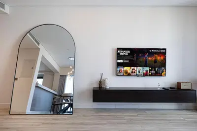 a living room with a mirror and a tv at Mahogany 1 - 2BR 6 PAX - Amazing Oasis - 1500 sqft in Dubai