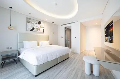 a bedroom with a large white bed and a desk at Mahogany 1 - 2BR 6 PAX - Amazing Oasis - 1500 sqft in Dubai