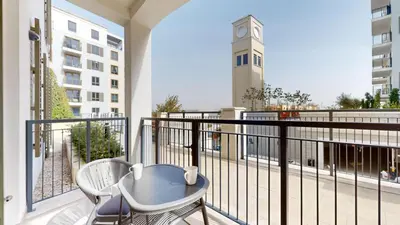 a balcony with a table and chairs and a clock tower at La Sirene 3 - Elegant Two Bedroom in Jumeirah 1 in Dubai