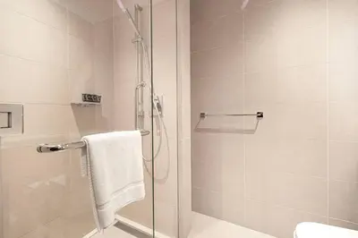a bathroom with a shower with a glass door at High Floor Marina Gate 1 Bdr Flat Only Stays in Dubai