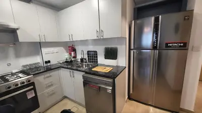 a kitchen with a stainless steel refrigerator and white cabinets at Modern 2BR -5min to Metro-Unit 211 in Dubai