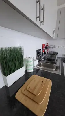 a wooden cutting board on a counter in a kitchen at Modern 2BR -5min to Metro-Unit 211 in Dubai