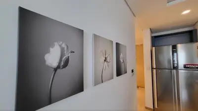 a room with a refrigerator and paintings on the wall at Modern 2BR -5min to Metro-Unit 211 in Dubai