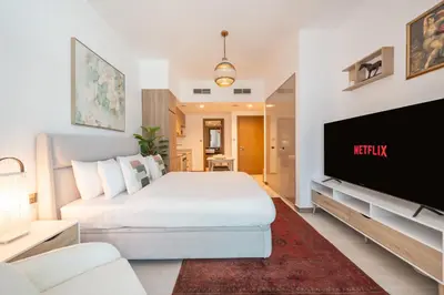 a bedroom with a bed and a flat screen tv at Sophisticated Studio Escape Luxury Design in Dubai