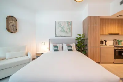 a bedroom with a large white bed and a couch at Sophisticated Studio Escape Luxury Design in Dubai