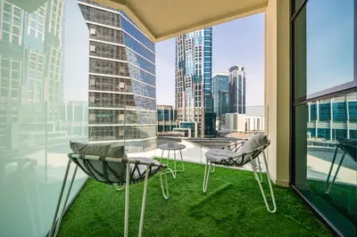 a balcony with two chairs and a view of the city at Sophisticated Studio Escape Luxury Design in Dubai