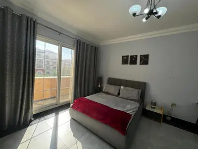 a bedroom with a bed and a large window at Specious Fully furnished studio in May residence in Dubai