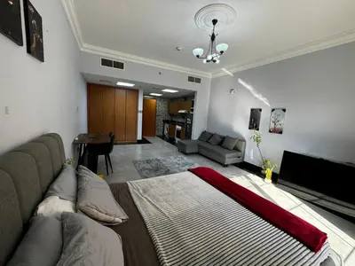a living room with a large bed and a couch at Specious Fully furnished studio in May residence in Dubai