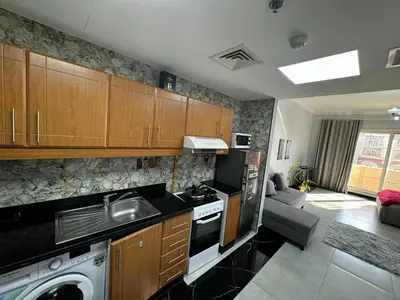 a kitchen with a sink and a stove top oven at Specious Fully furnished studio in May residence in Dubai