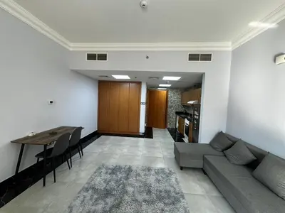 a living room with a couch and a table at Specious Fully furnished studio in May residence in Dubai