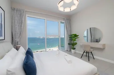 a bedroom with a large white bed and a large window at Beautiful 2 Bedroom Sea Views at La Vie JBR in Dubai