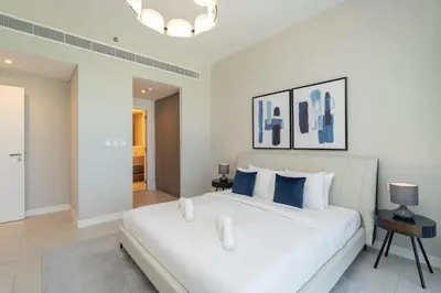 a bedroom with a large white bed with blue pillows at Beautiful 2 Bedroom Sea Views at La Vie JBR in Dubai