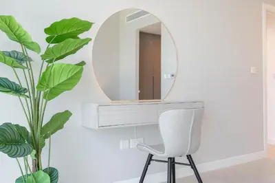 a mirror and a chair in a room with a plant at Beautiful 2 Bedroom Sea Views at La Vie JBR in Dubai