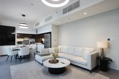 a living room with a white couch and a table at Waterfront 2BR with Dubai Skyline Views in Dubai