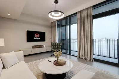 a living room with a couch and a tv at Waterfront 2BR with Dubai Skyline Views in Dubai