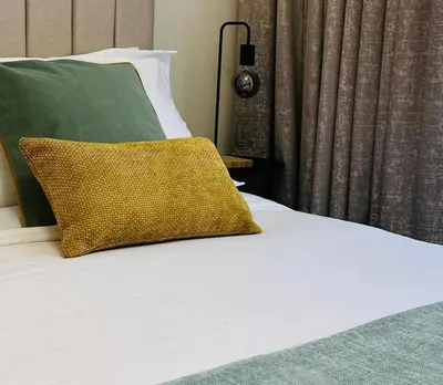 a bed with a yellow pillow on top of it at Brand New Studio Near Burj khalifa & Dubai Mall in Dubai