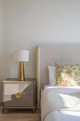 a bed with a nightstand with a lamp on it at Frank Porter - Amna Tower in Dubai
