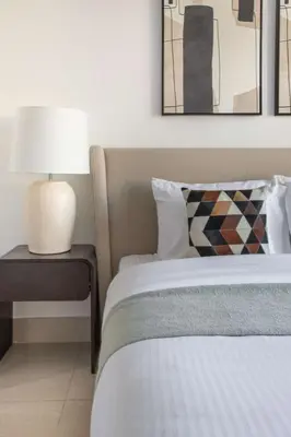 a bedroom with a bed and a table with a lamp at Frank Porter - Tajer Tower E in Dubai