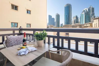 a table with a bottle of wine on a balcony at Frank Porter - Tajer Tower E in Dubai