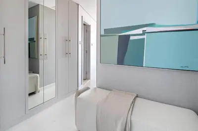 a white room with a white bench and a mirror at Frank Porter - Damac Heights in Dubai
