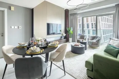 a dining room and living room with a table and chairs at Frank Porter - Damac Heights in Dubai