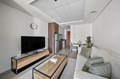 a living room with a couch and a flat screen tv at Stunning Lake View Apartment in JLT in Dubai