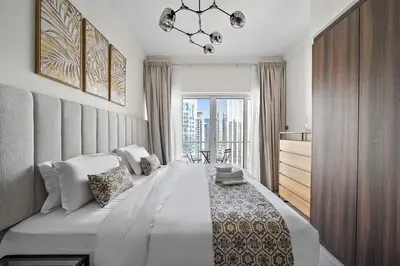a bedroom with a large bed and a large window at Stunning Lake View Apartment in JLT in Dubai