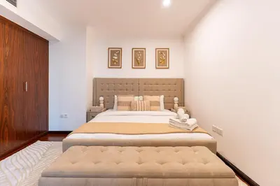 a bedroom with a large bed with a large ottoman at Chic 1-Bedroom Getaway with Downtown Living Charm in Dubai