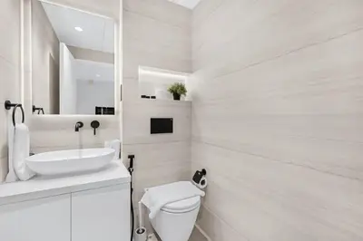 a white bathroom with a sink and a toilet at Luxury 2BR Apartment Near JBR Beach with Pool and Gym Access in Dubai