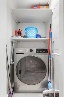 a kitchen with a washing machine in a small room at Luxury 2BR Apartment Near JBR Beach with Pool and Gym Access in Dubai