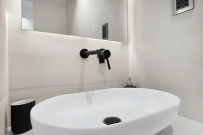 a white sink in a bathroom with a mirror at Luxury 2BR Apartment Near JBR Beach with Pool and Gym Access in Dubai