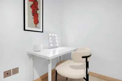 a white desk with a chair and a picture on the wall at Luxury 2BR Apartment Near JBR Beach with Pool and Gym Access in Dubai