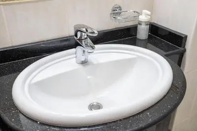 a white sink in a bathroom with a black counter at 1BHK in central of Dubai Marina in Dubai