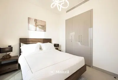 a bedroom with a white bed and a sliding glass door at 1BR Apartment in Sobha Hartland with Skyline Views in Dubai