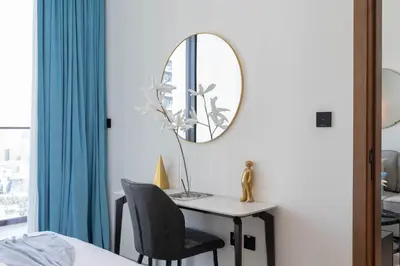 a bedroom with a desk with a mirror and a chair at Sky-High Serenity - Stylish 1BHK - 20th Floor in Dubai